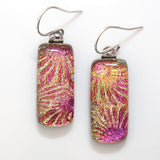 Pink and gold starburst pattern dichroic glass earrings. Rectangular shape, sparkly, shiny, glowing colour.
